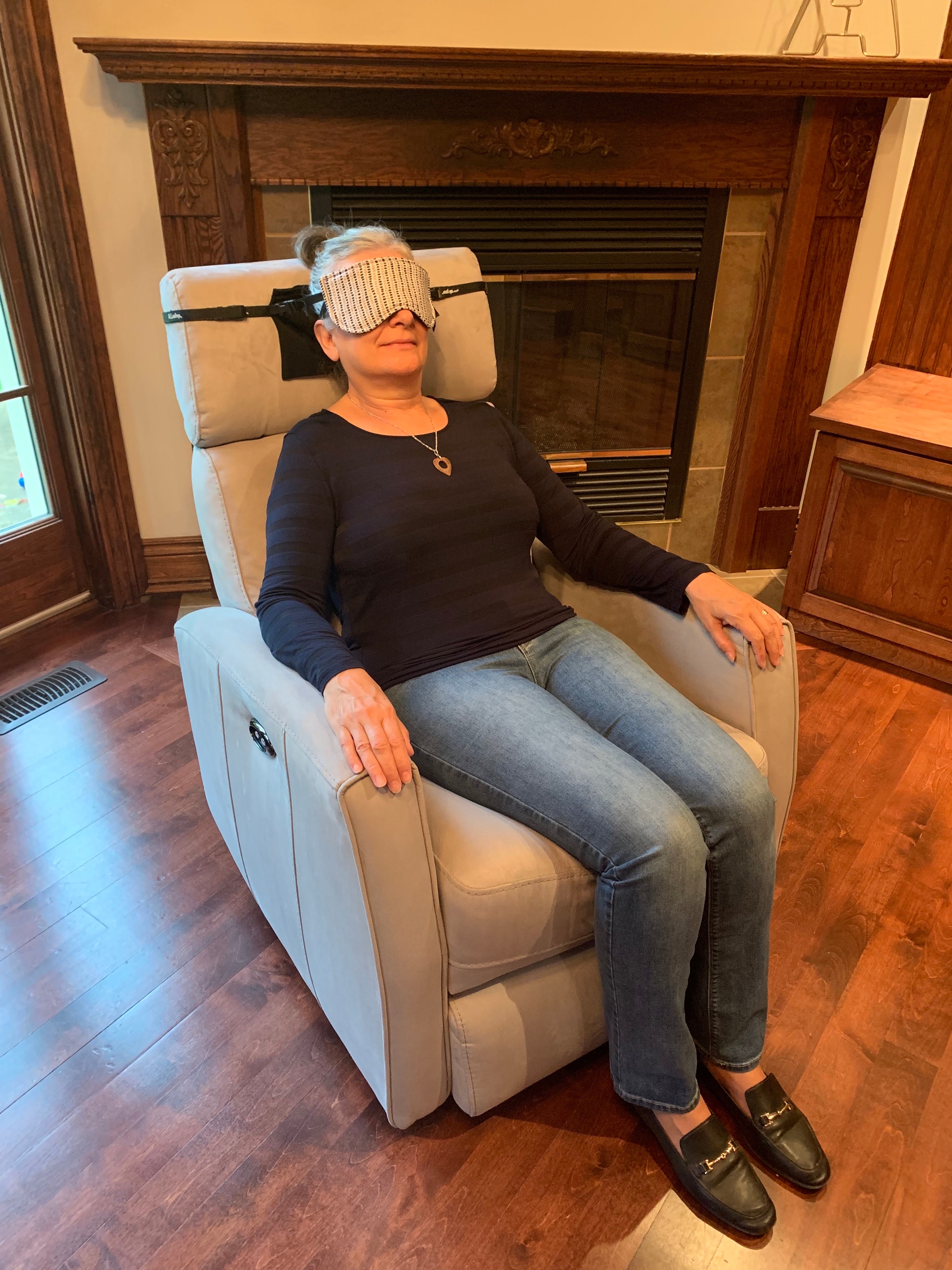 View from afar of a woman sleeping in a recliner style chair with ALLasleep and extension